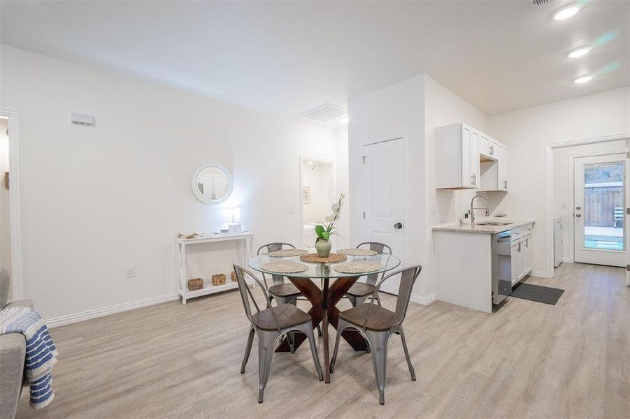 Dining area featuring light wood-type flooring and sink