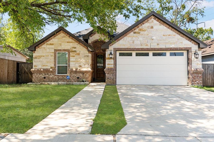 View of front of home with a garage and a front lawn