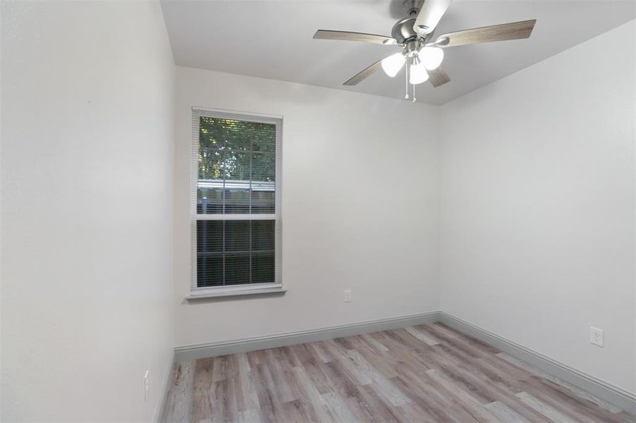 Unfurnished room featuring ceiling fan and light wood-type flooring