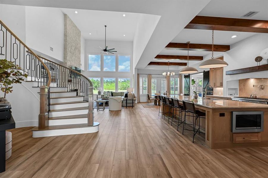 Elegant sweeping staircase flanked by expansive windows, bathing the space in natural light.