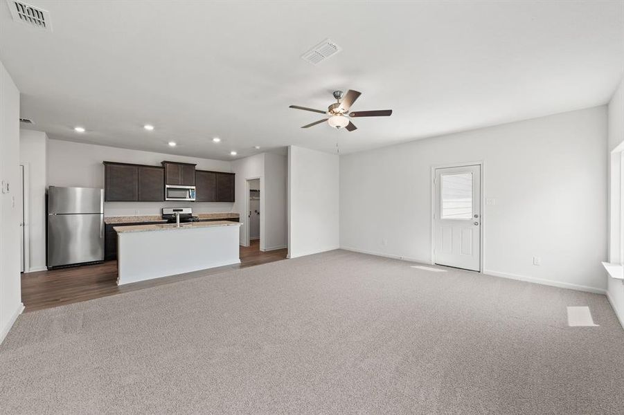 Living room featuring ceiling fan and light carpet