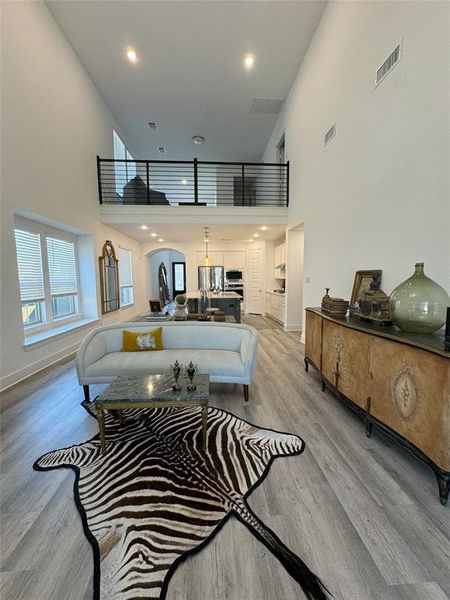 Living room featuring a high ceiling and light wood-type flooring