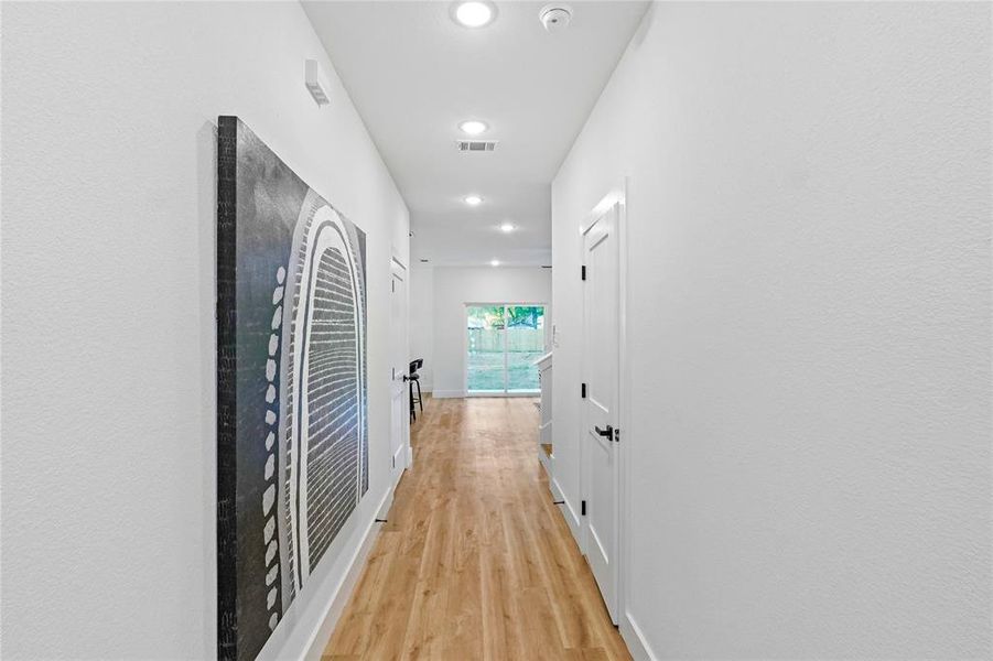 Hallway with light hardwood / wood-style flooring