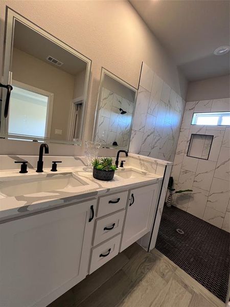 Bathroom featuring vanity and tiled shower