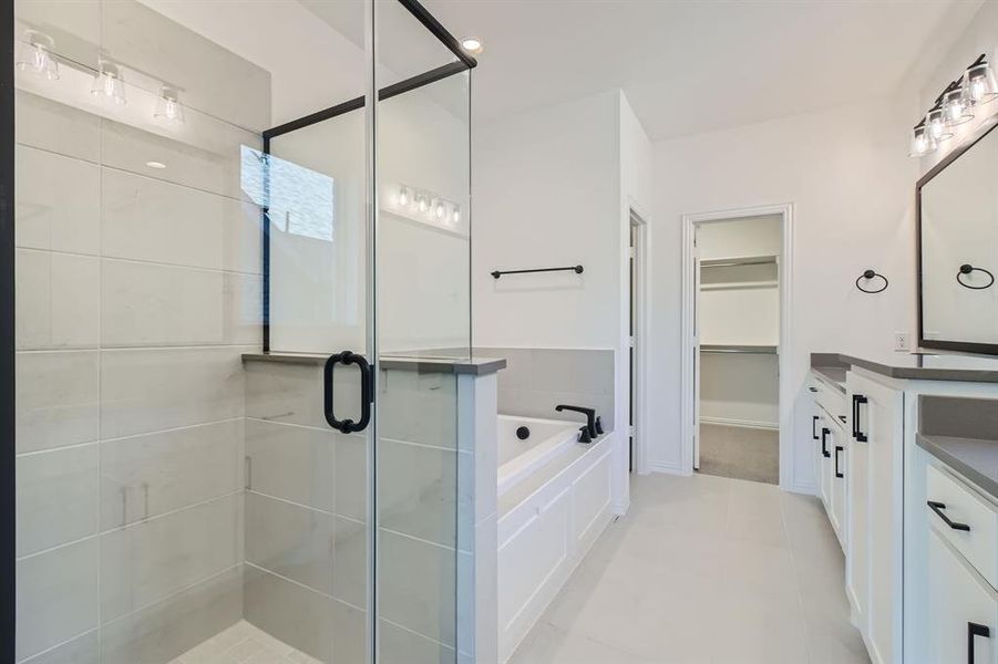 Bathroom featuring vanity, plus walk in shower, and tile patterned flooring