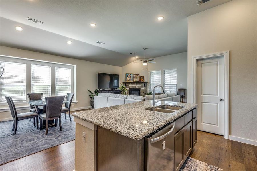 Kitchen featuring a center island with sink, stainless steel dishwasher, ceiling fan, and plenty of natural light