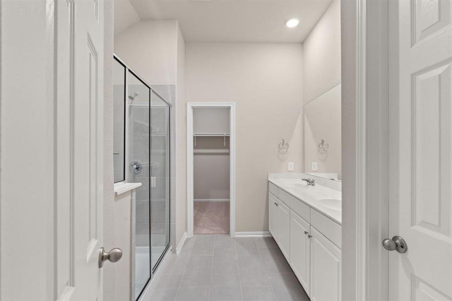 The en-suite bathroom offers a spa-like atmosphere with its elegant design, high end finishes, and tasteful lighting, creating a retreat within your own home.