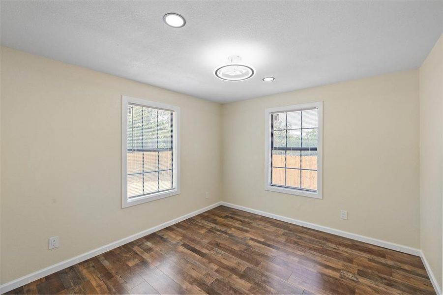 Unfurnished room with dark hardwood / wood-style flooring and a wealth of natural light