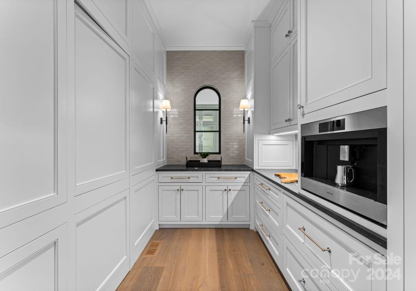 Push to open walk-in pantry, extensive storage, and Wolf espresso machine all included in the scullery.