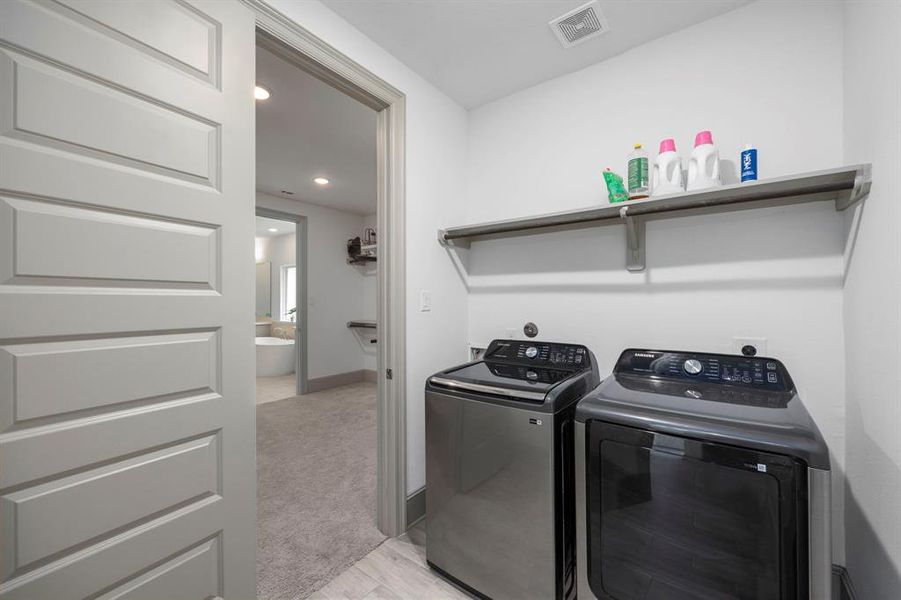 Large laundry room on first floor adjoins the primary bedroom closet that leads to the primary bathroom.