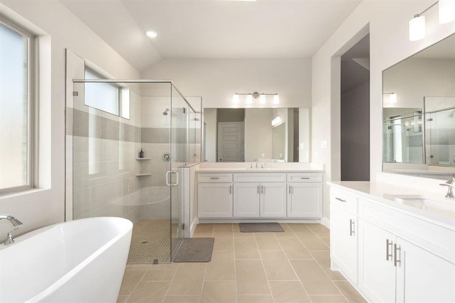 Bathroom featuring independent shower and bath, tile patterned flooring, vanity, and vaulted ceiling