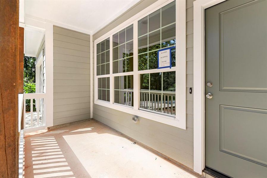 Lovely, country style front porch.  Exterior paint is gray with a charming green door.