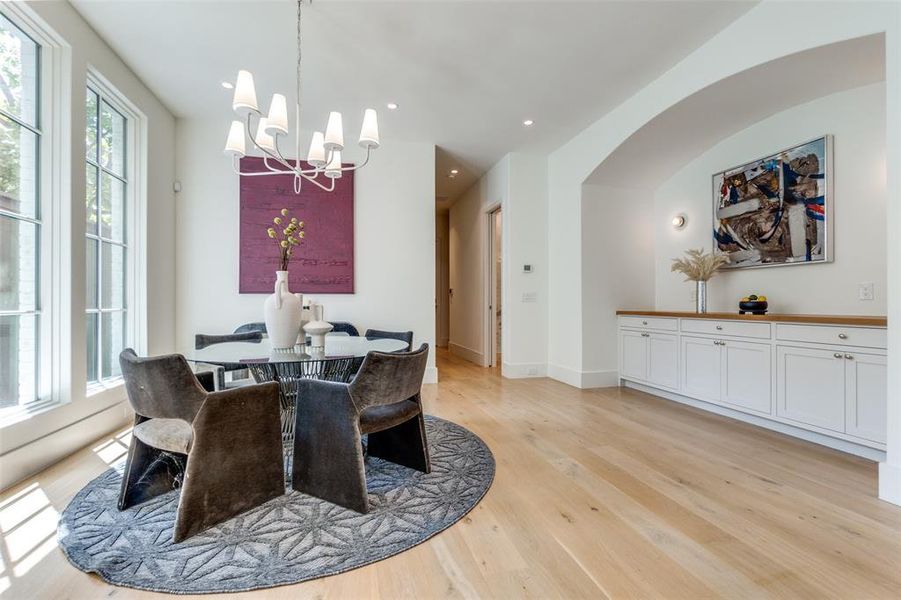 Dining room with light wood-type flooring, plenty of natural light, and a chandelier