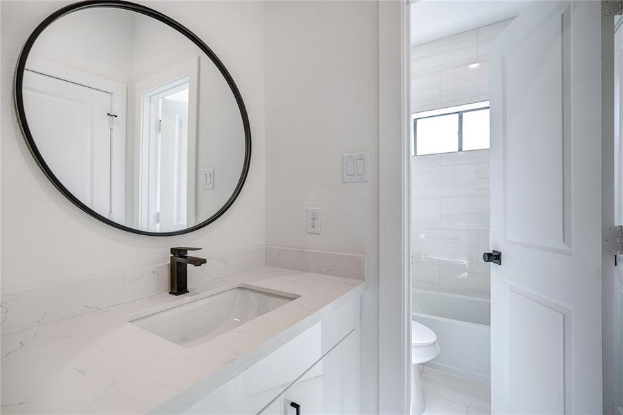 The bathroom has separate sinks with a shared bathtub and toilet