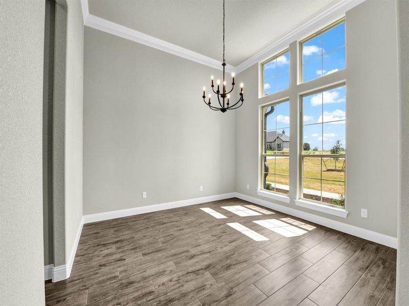 Unfurnished dining area with ornamental molding, a notable chandelier, and hardwood / wood-style flooring