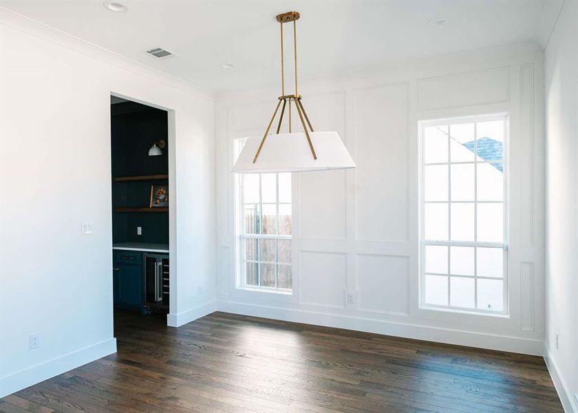 Unfurnished dining area with dark hardwood / wood-style floors, a healthy amount of sunlight, and built in features