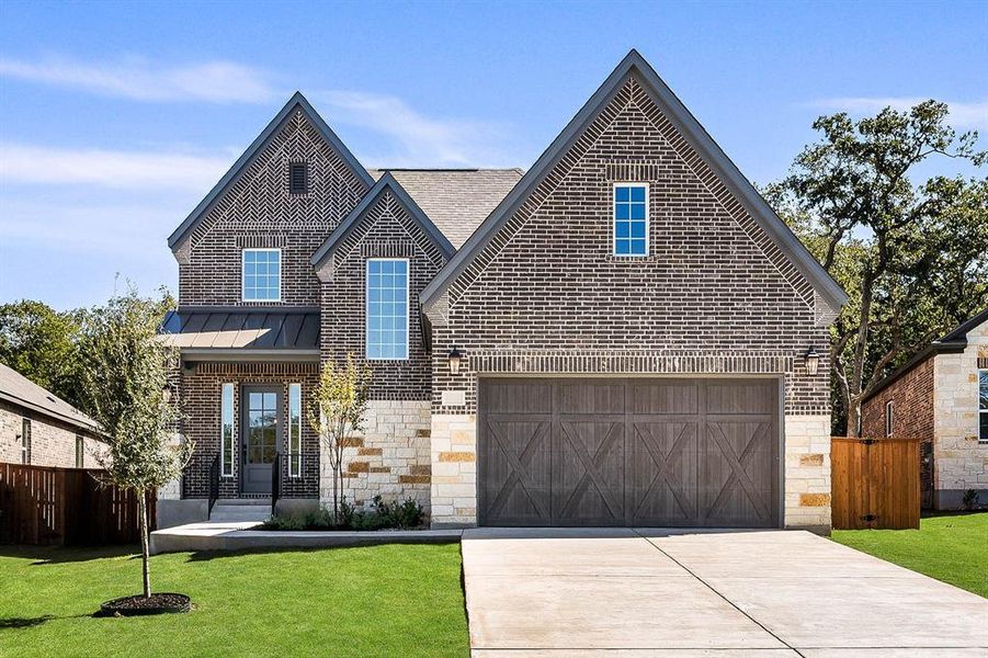 The Naomi plan at The Colony is a beautiful two-story home with a long driveway, gorgeous cedar garage door, and lush front yard landscaping.