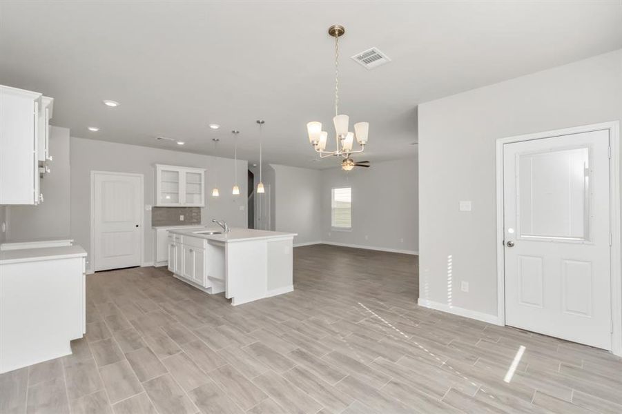 This dining area, adjacent to the modern kitchen, is perfect for both casual meals and formal dining. The room is bathed in natural light. The kitchen's open layout, complete with an island and sleek cabinetry, enhances the sense of space and connection. Whether hosting a dinner party or enjoying a quiet breakfast, this space offers the ideal setting. **This image is from another Saratoga Home with similar floor plan and finishes, not the June floorplan.**