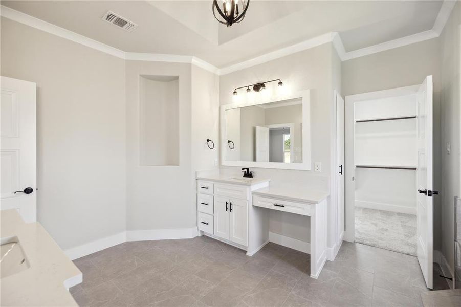 Bathroom with tile patterned floors, vanity, and crown molding