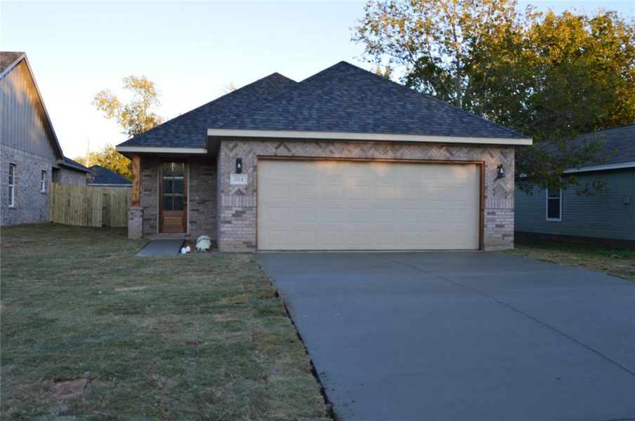 View of front of home featuring a front lawn and a garage