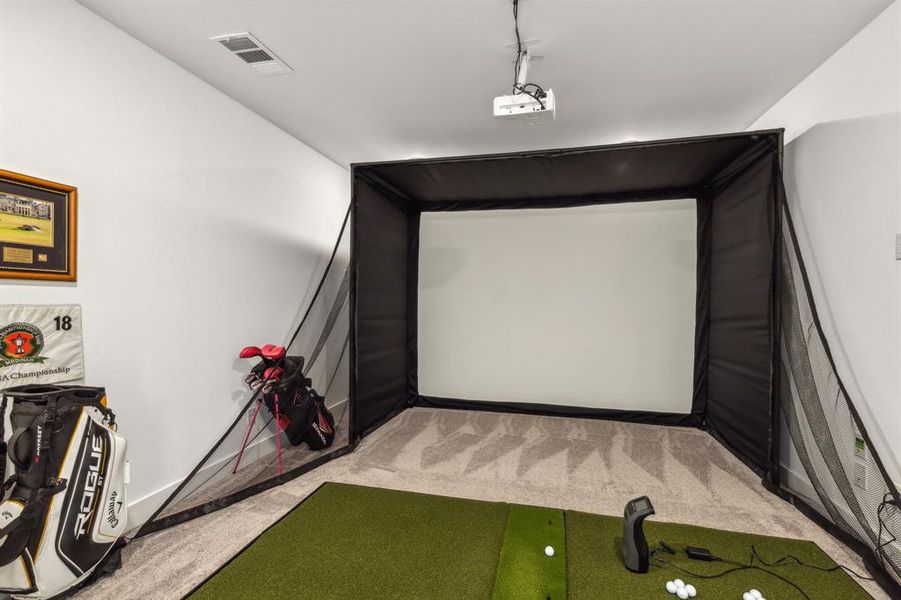2nd level media room featuring golf simulator and light colored carpet
