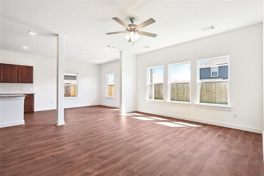 Unfurnished living room with ceiling fan and dark hardwood / wood-style floors