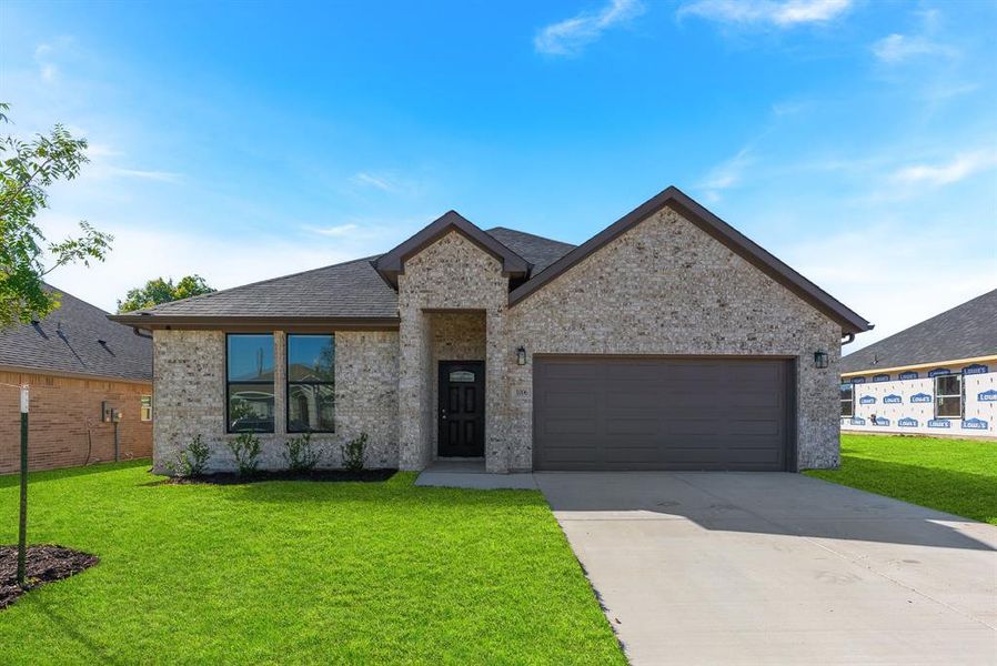 View of front facade featuring a garage and a front lawn