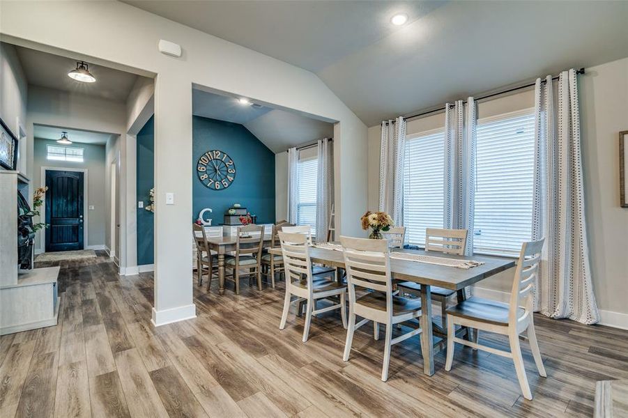 Dining area with wood-type flooring and lofted ceiling