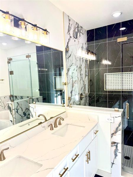 Bathroom with vanity, tile walls, and a shower with shower door