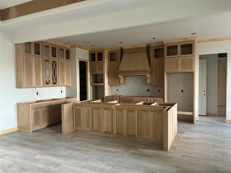 Kitchen featuring premium range hood, light wood-type flooring, and a kitchen island