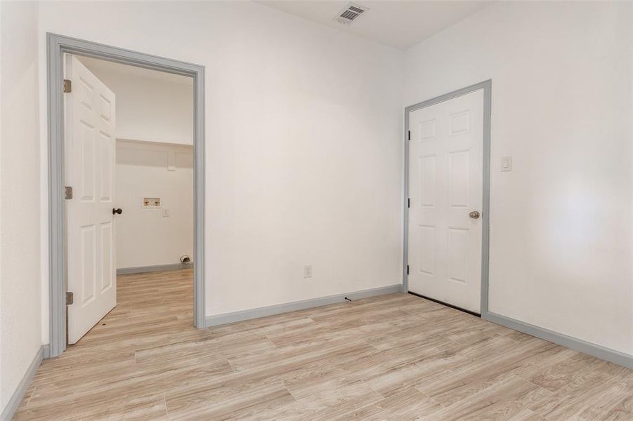 Unfurnished bedroom with a closet, a spacious closet, and light wood-type flooring