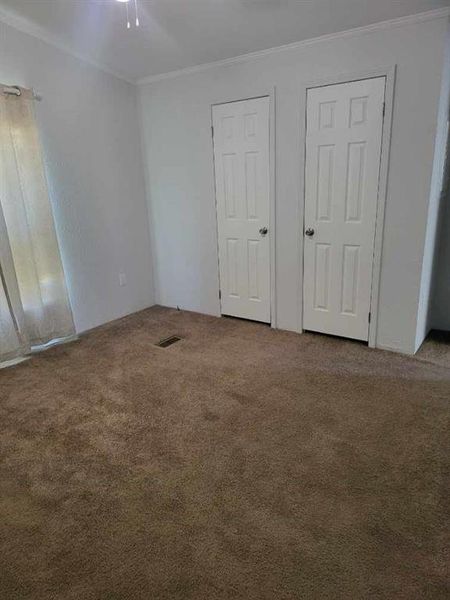 Carpeted spare room with crown molding