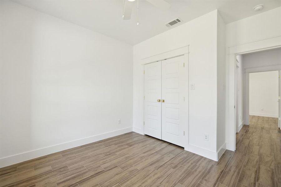 Unfurnished bedroom with a closet, light wood-type flooring, and ceiling fan