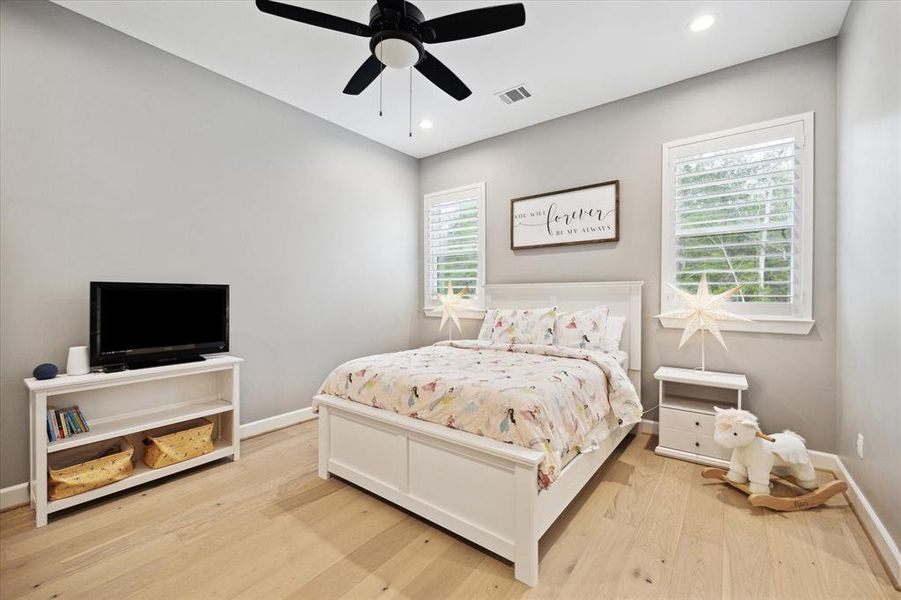 Secondary bedroom with engineered wood floors, recessed lighting, ceiling fan with a light, plantation shutters and is en suite.