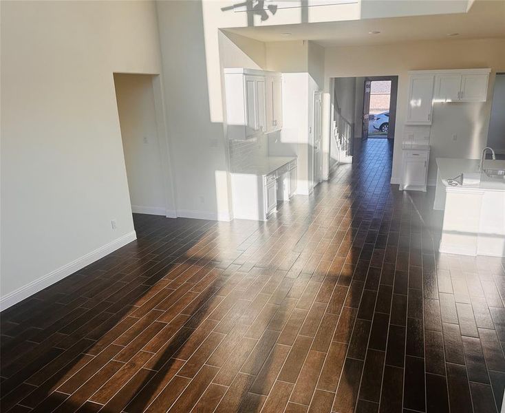 Unfurnished living room with dark hardwood / wood-style flooring and ceiling fan