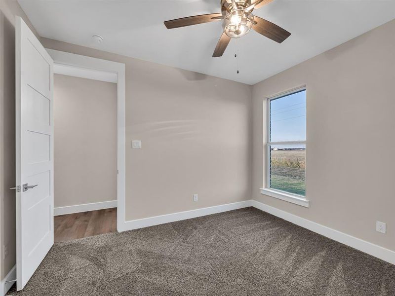 Unfurnished bedroom with ceiling fan and carpet