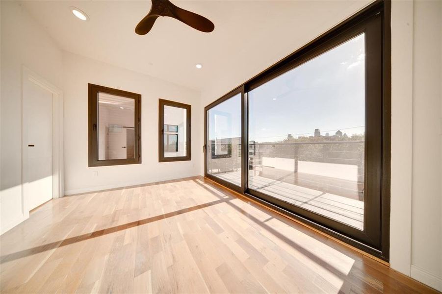 Empty room featuring light wood-type flooring and ceiling fan