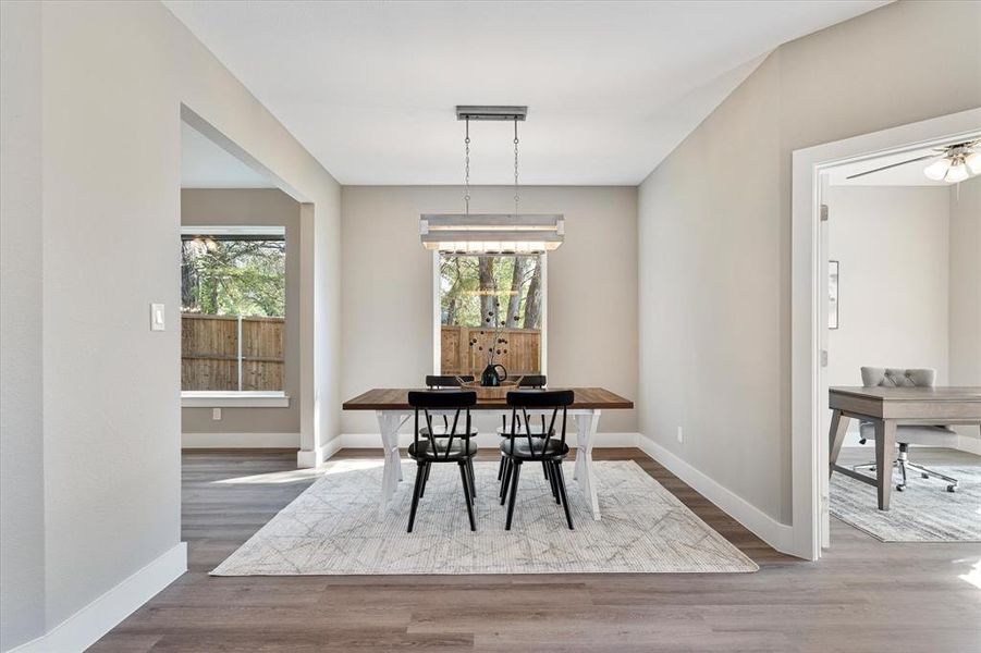 Dining area with hardwood / wood-style floors and ceiling fan with notable chandelier