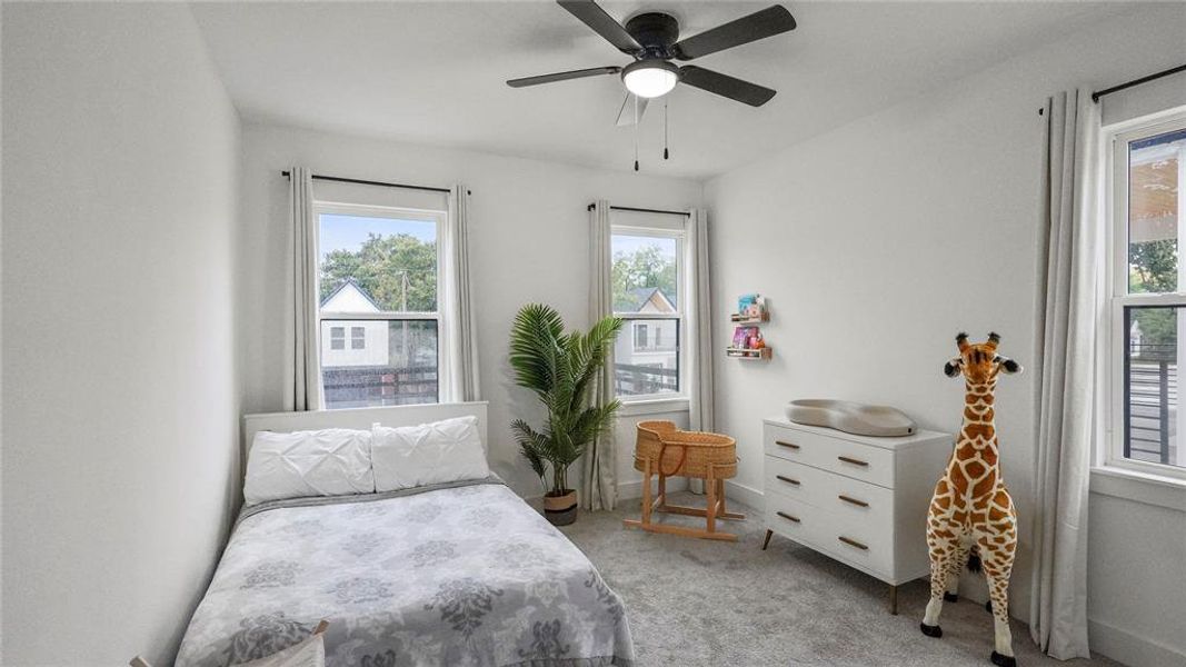 Bedroom with light colored carpet and ceiling fan