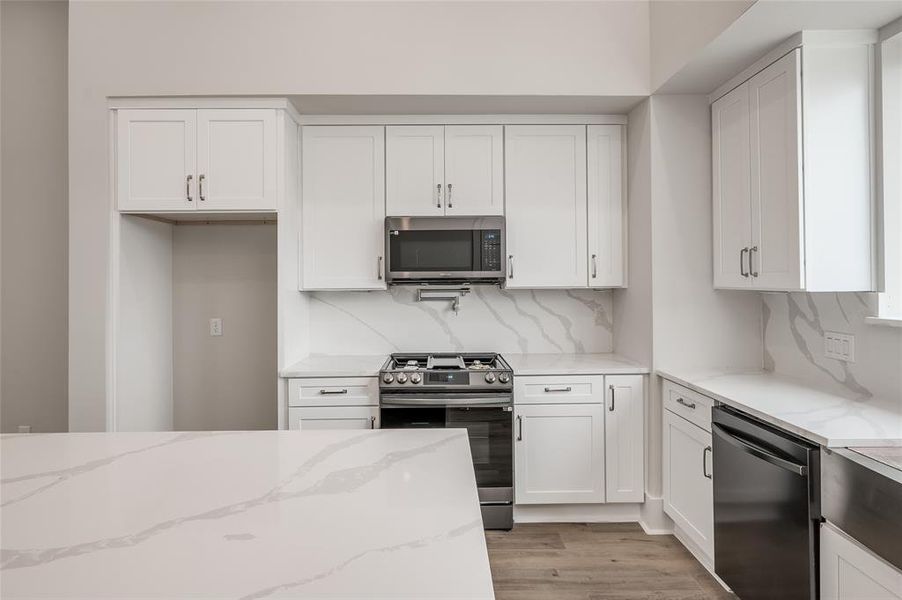 The kitchen features sleek high end appliances and quartz counters and backsplash. (Refrigerator will be included)