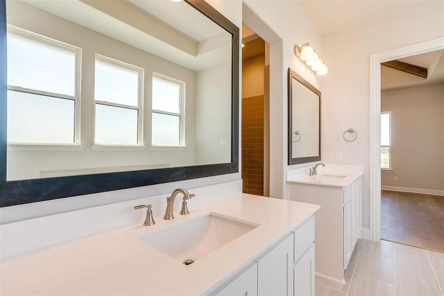 Bathroom featuring double sink vanity, hardwood / wood-style floors, and a wealth of natural light