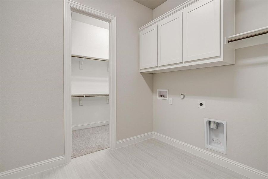 Laundry room with hookup for a washing machine, cabinets, gas dryer hookup, and hookup for an electric dryer