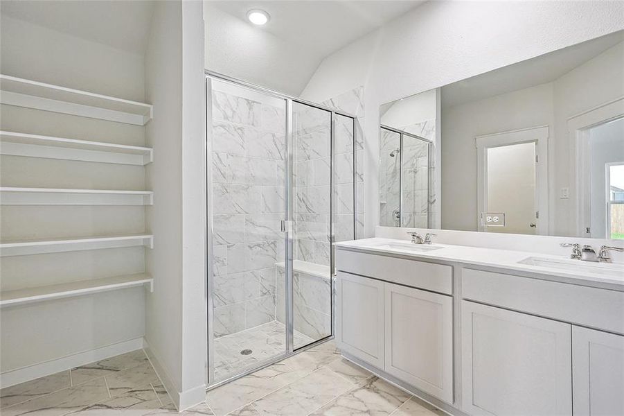 Bathroom with vanity, a shower with shower door, and tile patterned floors