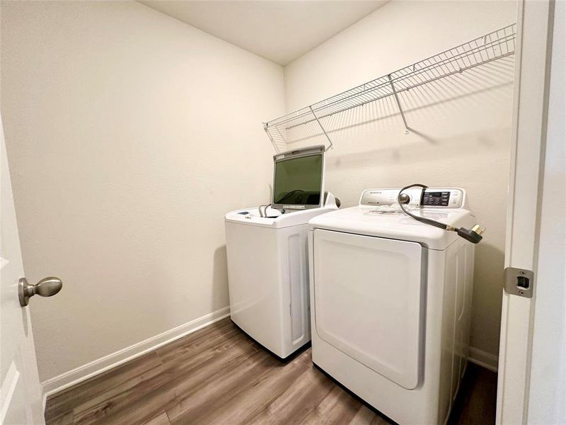 Washroom featuring washer and clothes dryer and hardwood / wood-style flooring