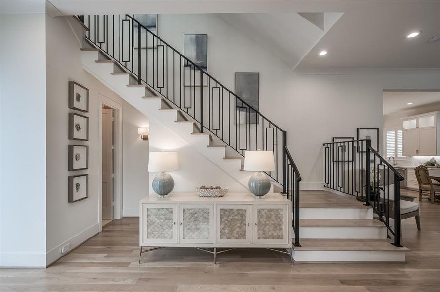 The beautifully designed staircase is situated to the left of the entry. The elegant powder room entry is to the far left.