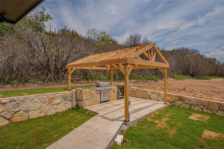 View of terrace with a pergola, exterior kitchen, and area for grilling