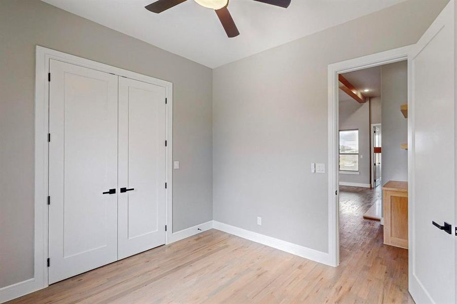 Unfurnished bedroom featuring a closet, light hardwood / wood-style floors, and ceiling fan