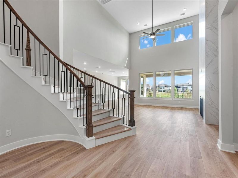 Breathtaking Foyer and Living SpaceUpon entering, you’re greeted by soaring high ceilings and tall windows that flood the space with natural light, creating a bright and airy ambiance. A stunning spiral staircase stands as a central feature, blending elegance and architectural charm. The expansive living area offers plenty of space for relaxation and entertaining, setting the stage for a home that’s both inviting and luxurious.