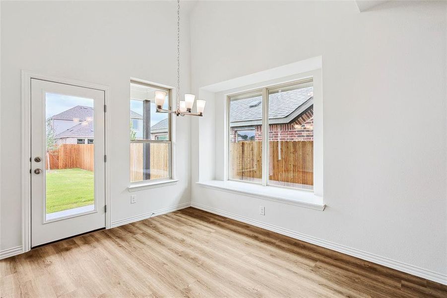 Unfurnished dining area featuring a notable chandelier and light hardwood / wood-style flooring