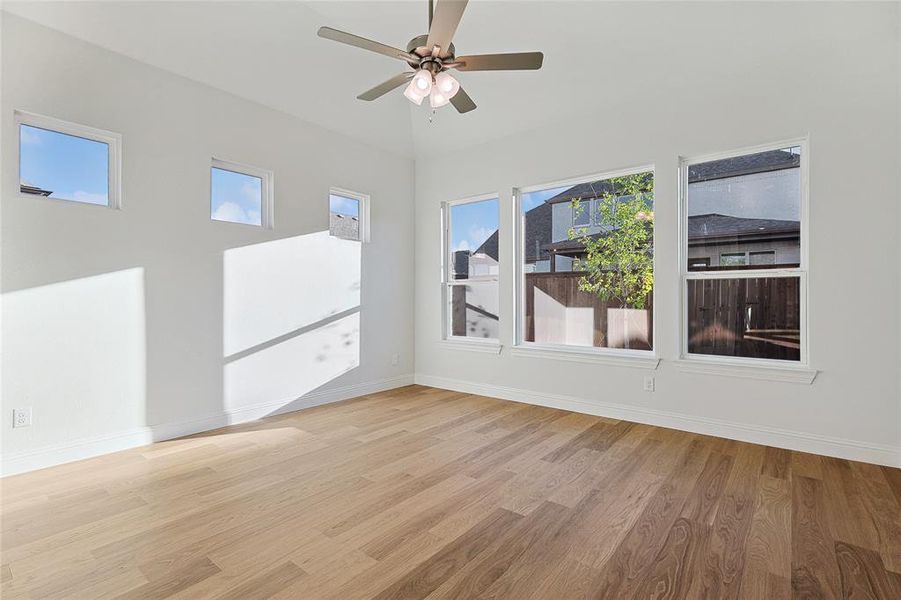 Spare room featuring light wood-type flooring, a wealth of natural light, and ceiling fan